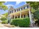 Attractive two-story brick home boasts black shutters, a covered porch, and lush green shrubbery at 6729 Garden Hill Dr, Huntersville, NC 28078