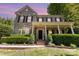 Charming two-story brick home featuring a welcoming front porch and manicured landscaping at 6729 Garden Hill Dr, Huntersville, NC 28078