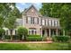 Charming two-story brick home with a manicured lawn, black shutters, and a welcoming front porch at 6729 Garden Hill Dr, Huntersville, NC 28078