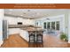 Open concept kitchen featuring white cabinetry, granite countertops, and seamless access to the sunroom with floor to ceiling windows at 6729 Garden Hill Dr, Huntersville, NC 28078