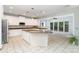 Bright kitchen boasting white cabinets, a granite countertop island, and a cozy sunroom with ample natural light at 6729 Garden Hill Dr, Huntersville, NC 28078