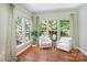 Bright sitting area features three large windows with views of a lush landscape and comfortable chairs at 6729 Garden Hill Dr, Huntersville, NC 28078