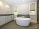 Bright bathroom featuring dual sinks, granite countertops and a luxurious free-standing tub at 7324 Leharne Dr, Charlotte, NC 28270