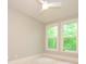 Bright bedroom featuring a ceiling fan and two windows overlooking a lush, green view at 7324 Leharne Dr, Charlotte, NC 28270