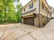 Home exterior featuring a two-car garage, complementary trim colors, and a paved driveway at 7324 Leharne Dr, Charlotte, NC 28270