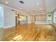 Open-concept living space with hardwood floors, recessed lights, and a modern kitchen in the background at 7324 Leharne Dr, Charlotte, NC 28270