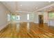 Bright living room with hardwood floors, large windows, and a stainless steel refrigerator at 7324 Leharne Dr, Charlotte, NC 28270