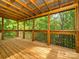 Inviting screened-in porch with wood flooring and view of lush, mature trees at 7324 Leharne Dr, Charlotte, NC 28270
