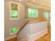 Staircase with wood banister leading to an open floorplan flooded with natural light at 7324 Leharne Dr, Charlotte, NC 28270