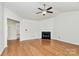 Bright living room featuring hardwood floors, fireplace, and ceiling fan at 9232 Four Mile Creek Rd, Charlotte, NC 28277