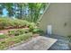 Back of house showing landscaped backyard with stone patio and retaining wall at 9526 Greyson Ridge Dr, Charlotte, NC 28277