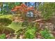 Secluded backyard with terraced garden, mature maple tree, and lush greenery at 9526 Greyson Ridge Dr, Charlotte, NC 28277