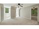 Neutral bedroom with two large windows, plush carpeting, and a ceiling fan at 9526 Greyson Ridge Dr, Charlotte, NC 28277