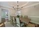 Comfortable dining room with tray ceilings, a chandelier, and a view of a built-in bookshelf in the other room at 9526 Greyson Ridge Dr, Charlotte, NC 28277