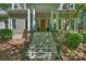 Inviting front entrance with elegant columns, a wooden door, and stone steps leading to the porch at 9526 Greyson Ridge Dr, Charlotte, NC 28277