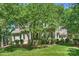 Lovely home exterior with lush landscaping and a covered front porch, shaded by mature trees at 9526 Greyson Ridge Dr, Charlotte, NC 28277