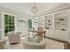 Well-lit home office featuring built-in shelves, a desk, chairs, and large windows offering natural light at 9526 Greyson Ridge Dr, Charlotte, NC 28277