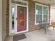 Charming front entrance with a red front door, stone facade, and a wrought iron bench at 1004 Craven St, Indian Trail, NC 28079