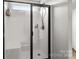 Modern bathroom shower with a black frame glass door and showerhead and white tiled walls at 1004 Craven St, Indian Trail, NC 28079