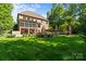 Spacious backyard with lush lawn, mature trees, and colorful flowerbeds, ideal for outdoor activities at 1009 Seminole Dr, Waxhaw, NC 28173