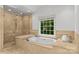 Bright bathroom featuring a soaking tub and large shower with light tile surround at 1009 Seminole Dr, Waxhaw, NC 28173
