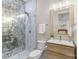 Modern bathroom with a glass-enclosed shower, marble tile, and a light wood vanity with a framed mirror at 1009 Seminole Dr, Waxhaw, NC 28173