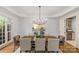 Bright dining room features modern chandelier, neutral colors, and adjacent wine storage at 1009 Seminole Dr, Waxhaw, NC 28173
