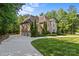 Stunning two-story brick home with a well-manicured lawn and extended driveway leading to a three-car garage at 1009 Seminole Dr, Waxhaw, NC 28173