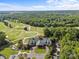 Aerial view of the golf course, a clubhouse, and surrounding trees, offering a scenic recreational setting at 1009 Seminole Dr, Waxhaw, NC 28173