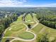 Scenic aerial view of a lush golf course with manicured greens, sand traps, and mature trees, perfect for golfers at 1009 Seminole Dr, Waxhaw, NC 28173