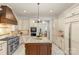 Open kitchen design featuring a stainless steel gas range, island, and custom cabinetry at 1009 Seminole Dr, Waxhaw, NC 28173