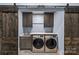 A modern laundry room with sliding barn door, utility sink, and front load washer and dryer at 1009 Seminole Dr, Waxhaw, NC 28173