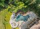 Aerial view of backyard pool and spa surrounded by lush landscaping and a patio area, perfect for entertaining at 1009 Seminole Dr, Waxhaw, NC 28173