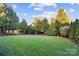 Expansive backyard features lush lawn and mature trees, creating a serene outdoor space with a hammock at 10115 Paxton Run Rd, Charlotte, NC 28277