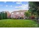 Large backyard with patio, lush lawn, mature trees, and brick exterior at 10115 Paxton Run Rd, Charlotte, NC 28277