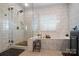 Elegant bathroom featuring a soaking tub, frameless shower, and modern tile finishes at 10115 Paxton Run Rd, Charlotte, NC 28277