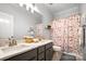 Bathroom with double sinks, granite countertop, and shower with patterned curtain at 10115 Paxton Run Rd, Charlotte, NC 28277