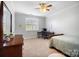 Spacious bedroom featuring a ceiling fan, window with blinds, and desk area at 10115 Paxton Run Rd, Charlotte, NC 28277