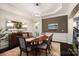 Elegant dining room with wainscoting, tray ceiling, modern chandelier, and hardwood floors at 10115 Paxton Run Rd, Charlotte, NC 28277