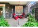 Cozy front porch with red Adirondack chairs, stone accents, and lush greenery at 10115 Paxton Run Rd, Charlotte, NC 28277