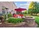 Brick patio featuring outdoor seating, fire pit, grill, and lush landscaping at 10115 Paxton Run Rd, Charlotte, NC 28277