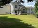 Backyard features a green lawn, patio with furniture and sunroom addition at 12244 Wallace Ridge Dr, Charlotte, NC 28269