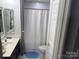 Bathroom features a white shower curtain, blue bath mat, and a vanity with a mirror at 12244 Wallace Ridge Dr, Charlotte, NC 28269
