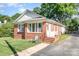 Cozy single-story brick home features a quaint front porch and an inviting entrance, set in a lush, green yard at 124 10Th Sw St, Conover, NC 28613