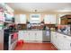Efficient kitchen featuring white cabinets, stainless steel appliances, and durable hardwood floors for practical living at 124 10Th Sw St, Conover, NC 28613