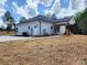 Rear exterior showcases a covered patio, a white siding with black accents, and a green lawn at 1247 Beltline Rd # 1, Chester, SC 29706
