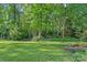 Spacious and lush backyard featuring mature trees, grassy lawn, and a potting shed at 1400 Coachman Dr, Waxhaw, NC 28173