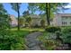 Beautifully landscaped backyard featuring a stone path, lush garden, and a charming bench at 1400 Coachman Dr, Waxhaw, NC 28173