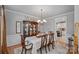 Elegant dining room with hardwood floors, chandelier, wainscoting, and a glimpse into the kitchen at 1400 Coachman Dr, Waxhaw, NC 28173