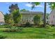 Back exterior featuring a screened porch, a wooden deck, and lush landscaping at 1400 Coachman Dr, Waxhaw, NC 28173